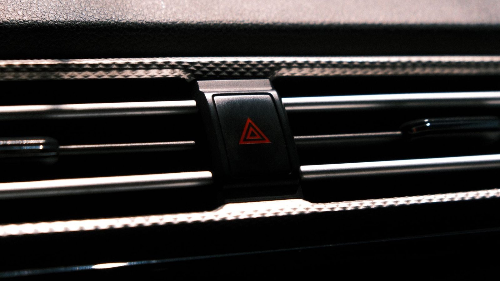 Close-up of a car's hazard light button on a dashboard